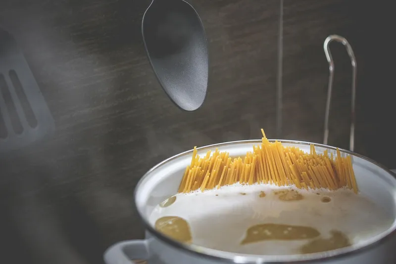 Spaghetti kokas i kastrull på spisen